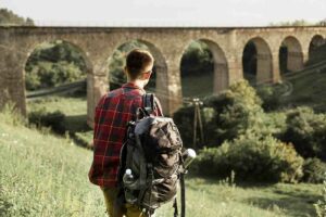 man-with-backpack-green-field